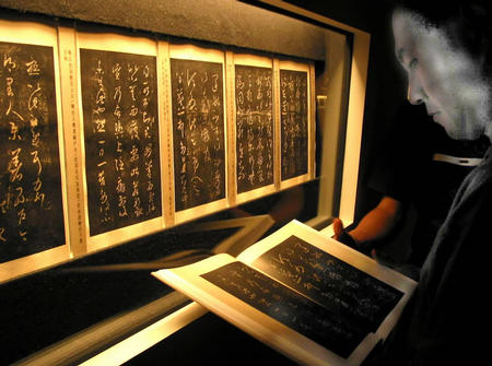 9月24日，一位书法爱好者在展厅里仔细研读王羲之的法帖。新华社记者 任珑 摄
